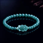 Blue green jade lotus bracelet worn by woman