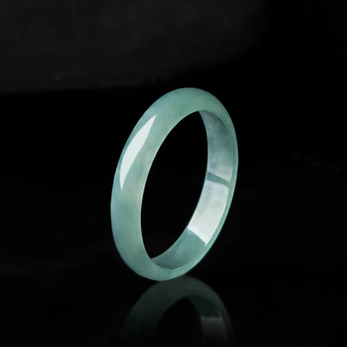 Blue green jadeite band ring worn by woman