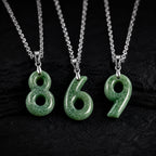 Green jade number pendants 8 6 and 9 on black background